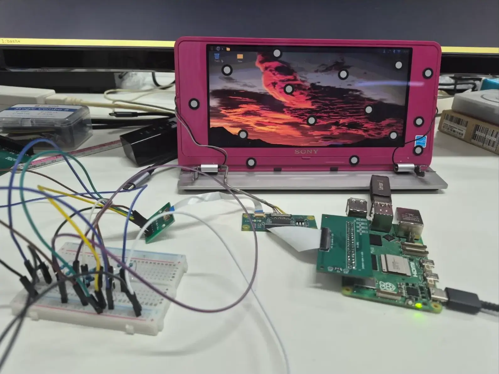 Pink VAIO P lid showing a desktop, driven from a Raspberry Pi 5 and the Koyomi LVDS board on the bench