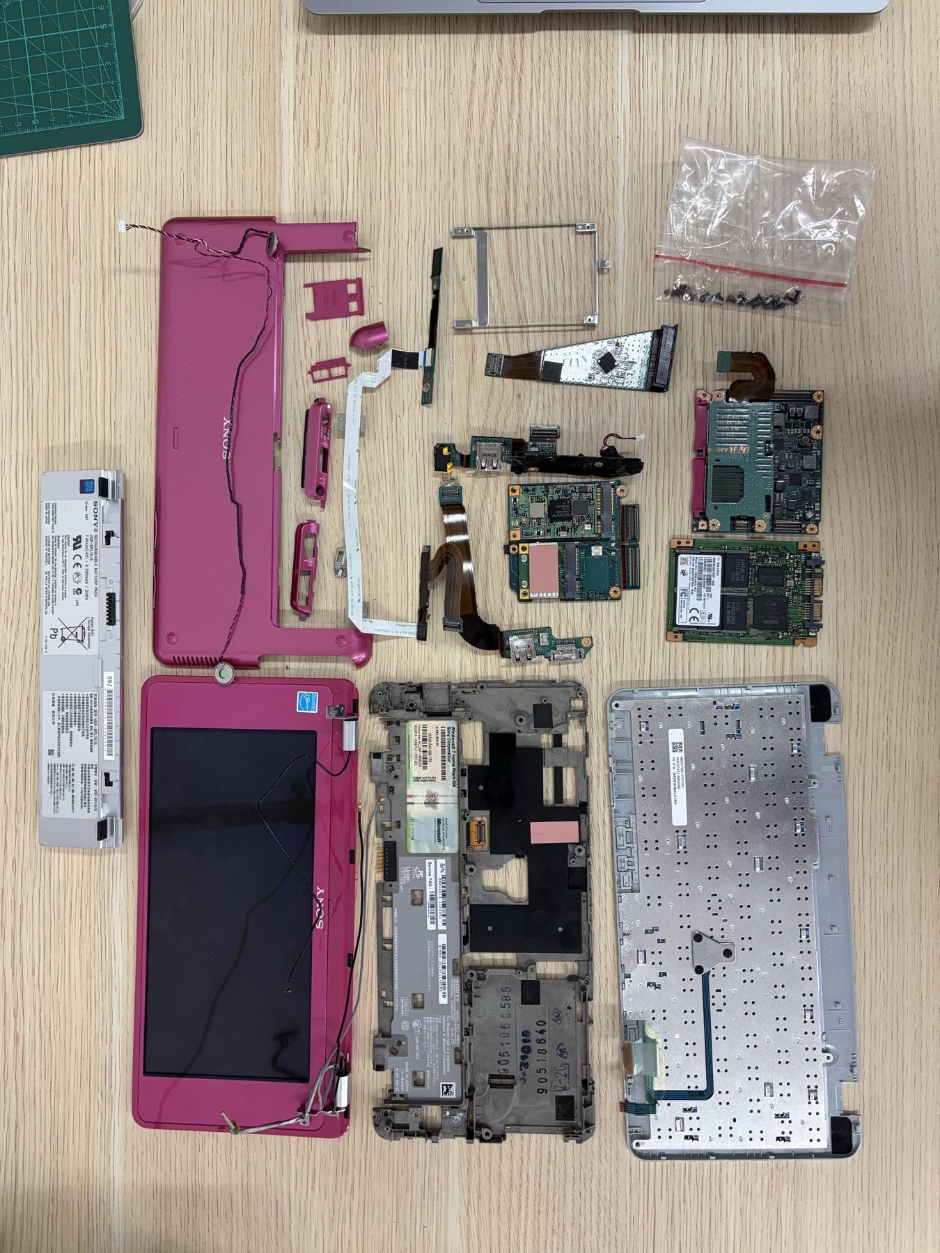 Sony VAIO P disassembled parts laid out for Raspberry Pi CM5 carrier-board planning