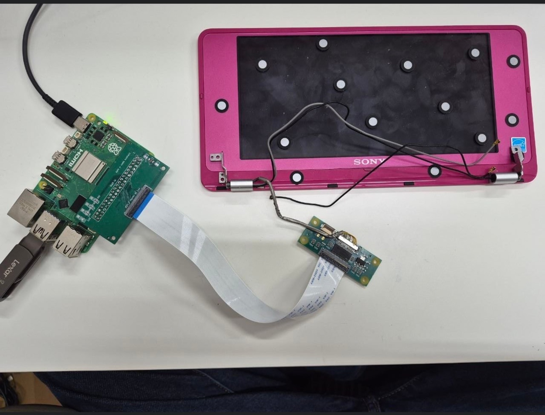 Raspberry Pi and LVDS interface boards connected to a disassembled Sony VAIO P display on a workbench